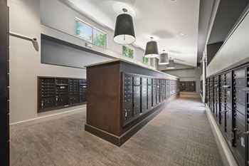 A long hallway with a row of lockers on the right and a wooden cabinet in the middle.